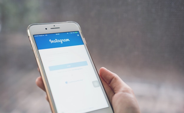 Foto hand drückt das login-bildschirm instagram-symbol