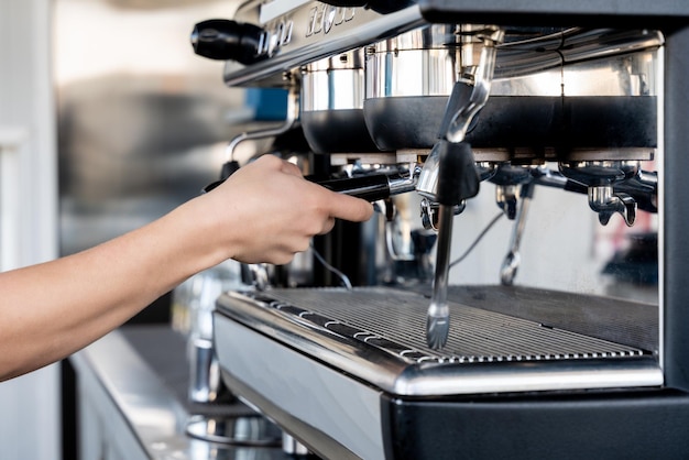 Hand einer Bardame beim Kaffeetrinken an der Maschine