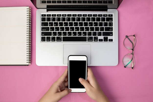 Hand einer Frau, die leeren Bildschirm des Smartphones auf Bürotisch verwendet.