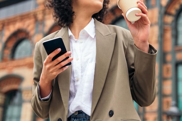 Hand einer Geschäftsfrau, die einen Handy hält