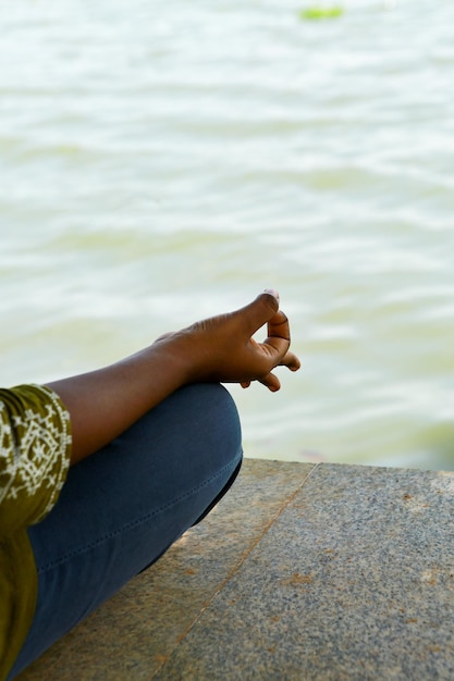 Foto hand eines mädchens, das auf einem strand yoga macht