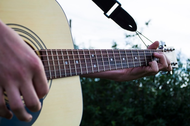 Hand eines Mannes, der Gitarre im Landhausstil spielt