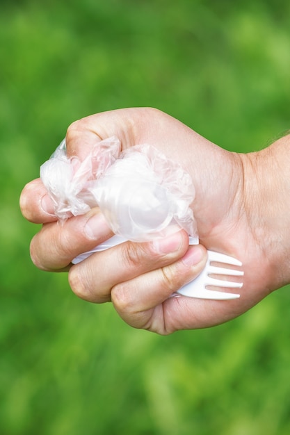 Hand eines Mannes, der Plastikmüll hält