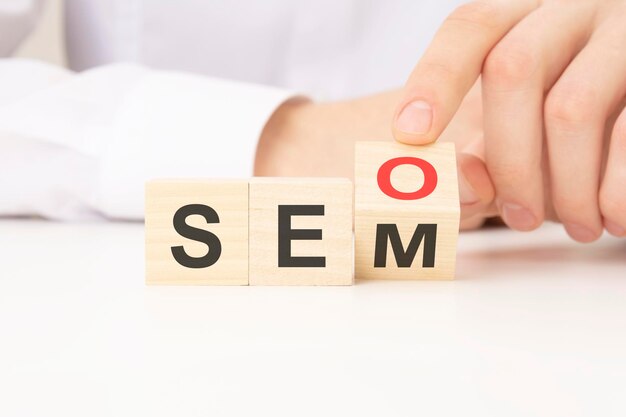Hand flip SEO para blocos de cubo de madeira de texto SEM no fundo da mesa otimização de mecanismos de busca publicidade ideia estratégia conceito de marketing