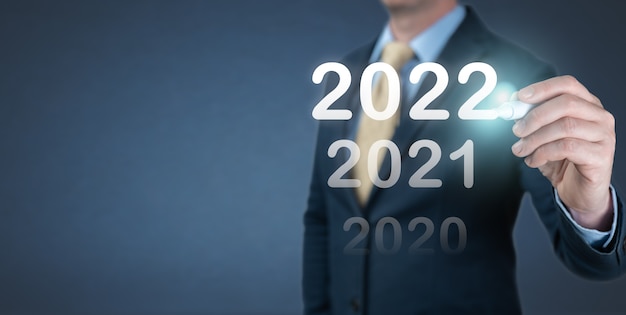 Hand Geschäftsmann 2022 Nummer auf virtuellen Bildschirm schreiben. Geschäfts- und Technologieziel festgelegte Ziele und Erreichung im Jahr 2022 Neujahrsvorsatz, Planungs- und Startstrategien und -ideen