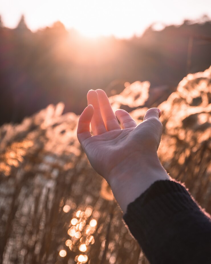 Hand greift nach der Sonne
