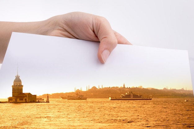 Hand hält ein Blatt Papier mit Blick auf Istanbul darauf