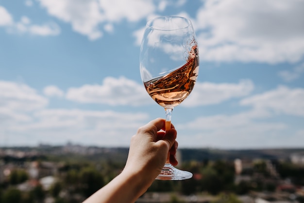 Hand hält ein Glas Wein