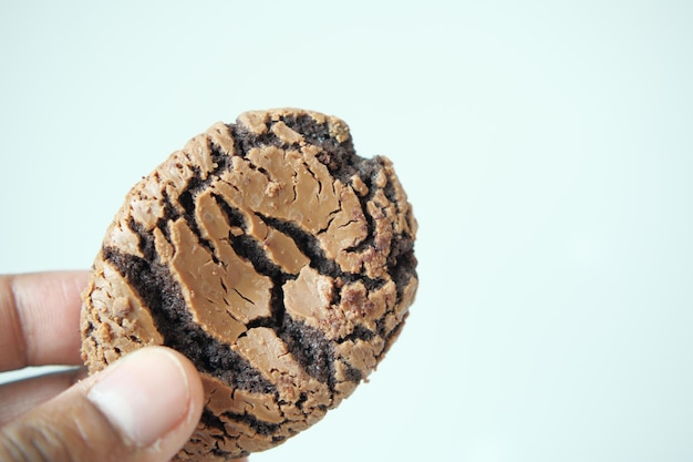 Hand hält ein schokoladensüßes Plätzchen