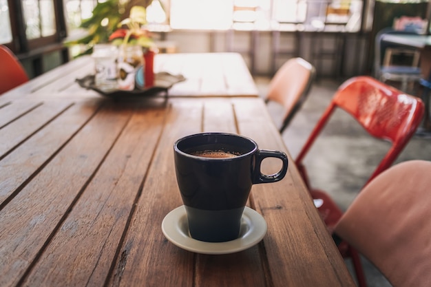 Hand hält eine Tasse heißen Kakao in einem Café