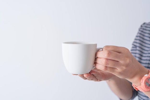 Hand hält eine Tasse Kaffee auf weißem Hintergrund isolieren Asiatische Frauenhand mit weißem Kaffee