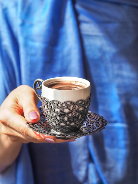 Hand hält eine Tasse Kaffee.