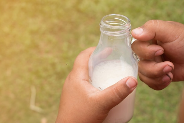 Hand hält Milchflasche.