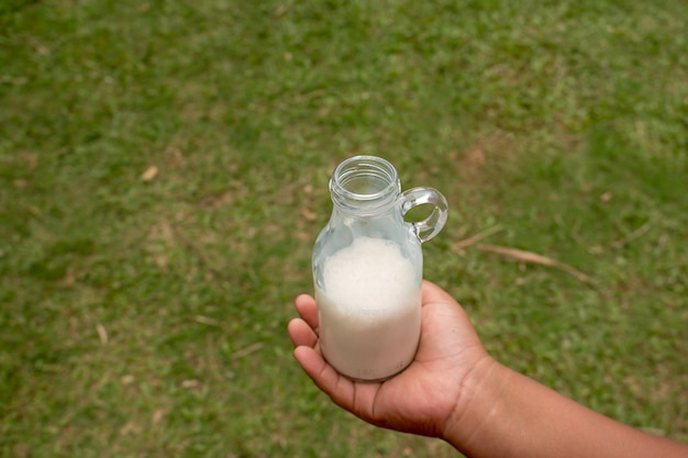 Hand hält Milchflasche.