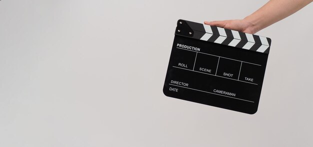 Hand hält schwarze Klappe oder Filmtafel auf weißem Hintergrund.