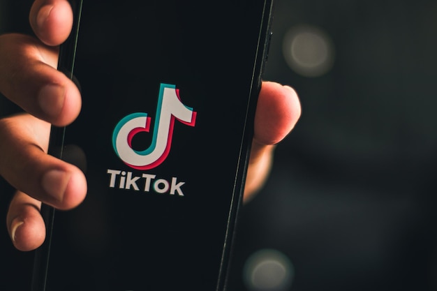 Hand hält Smartphone mit Bildschirm Tiktok-Logo-Plattform Online-Trend Welttanztrend