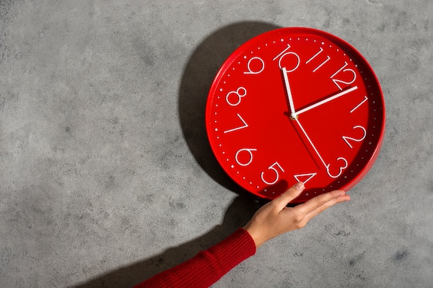 Hand hält Stillleben mit der Wanduhr