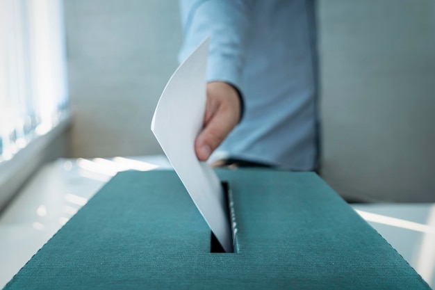 Hand hält Stimmzettel für Wahlabstimmung Konzept Mann stimmt bei einer Wahl das Referendum ab