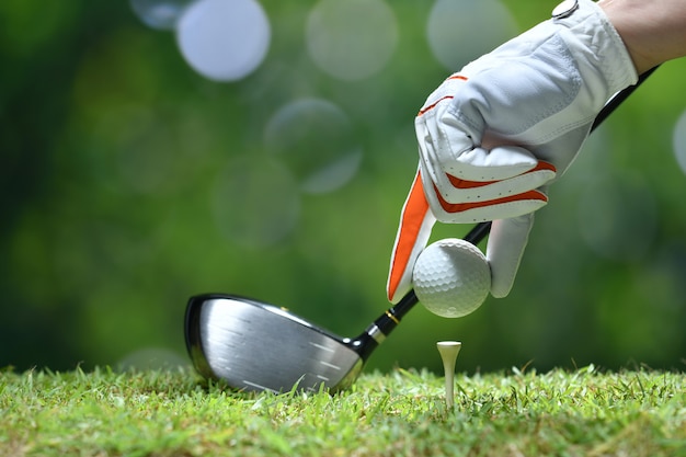 Hand halten golfball mit abschlag auf dem golfplatz