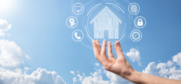 Hand halten Haussymbol. Smart Home gesteuertes, intelligentes Haus und Hausautomatisierungs-App-Konzept. PCB-Design und Person mit Smartphone. Innovation-Technologie-Internet-Netzwerk-Konzept.