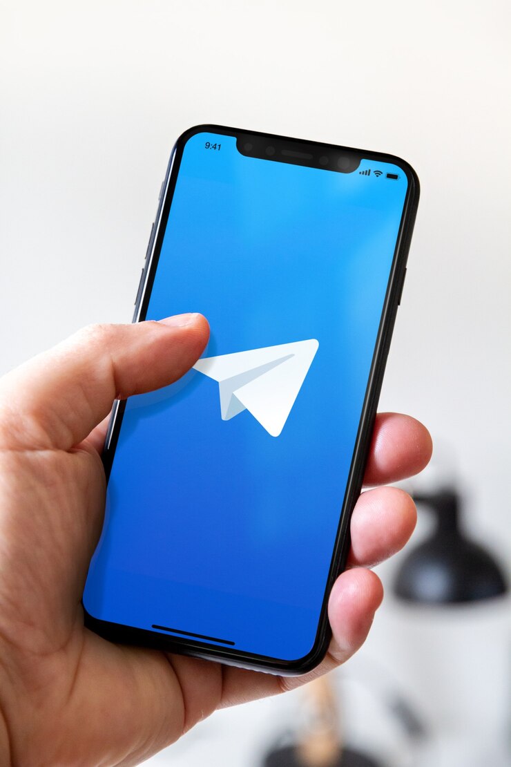 Foto hand halten telefon smartphone mit telegramm logo