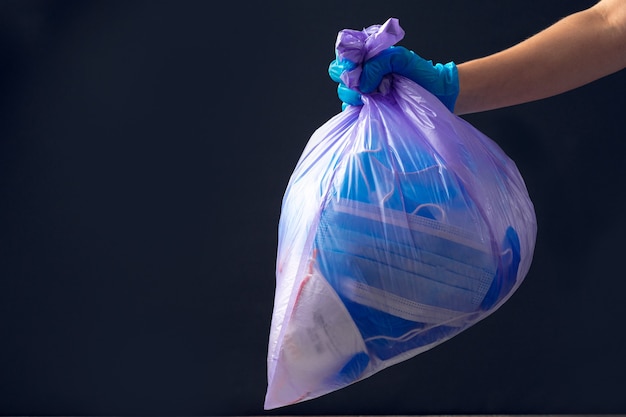Hand in medizinischen Handschuh werfen Müllsack