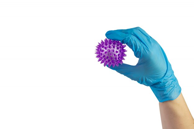 Hand in sterilen Handschuhen mit einem Molekülmodell des Virus von COVID-19