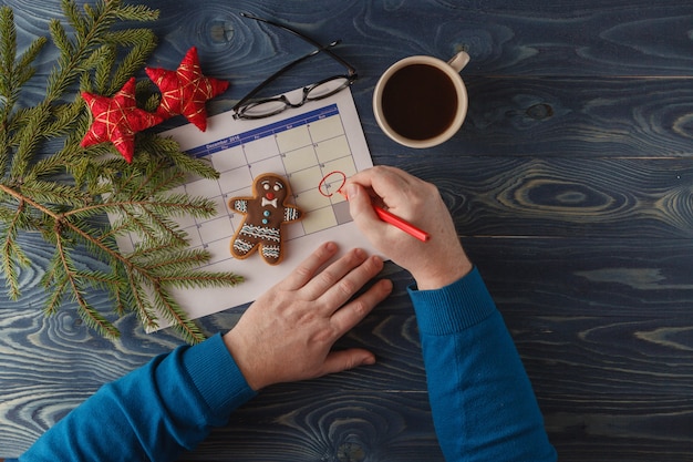 Hand markieren Sie Weihnachtsdatum auf einem Kalender