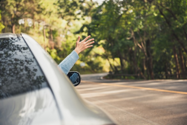 Hand mit erhobenem Arm entspannend und genießend den Roadtrip