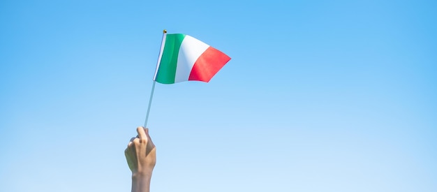 Hand mit italienischer Flagge auf Naturhintergrund Nationalfeiertag Tag der Republik Festa della Repubblica und fröhliche Feierkonzepte