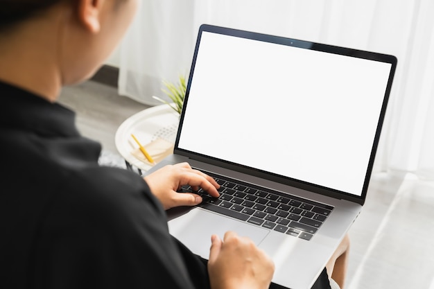 Hand mit Laptop mit leerem Bildschirm für Ihre Werbung. auf dem Tisch im Büro.