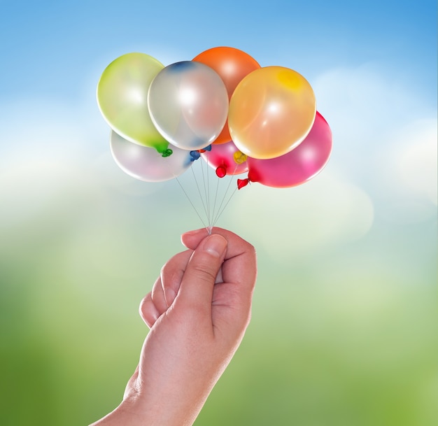 Foto hand mit luftballons auf hellem hintergrundunschärfe