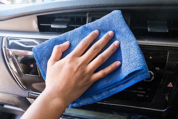 Hand mit Mikrofaser Tuch Reinigung Interieur modernes Auto.