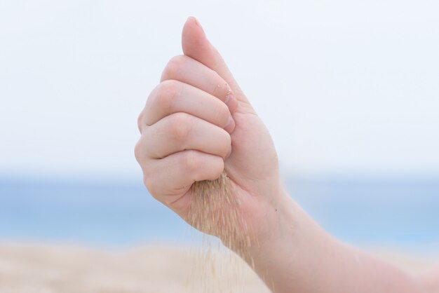 Hand mit Sand am Strand