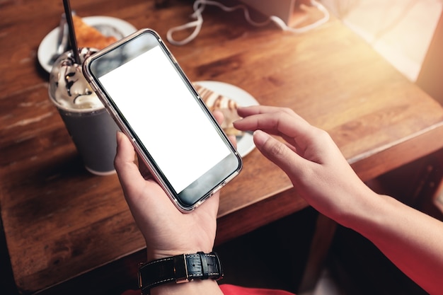 Hand mit Smartphone im Coffee Shopund weiches Licht