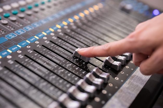 Hand mit Sound-Mixer-Bedienfeld in der Veranstaltungshalle