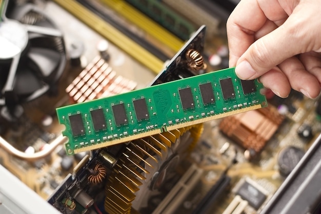 Hand mit Speicher auf einem Computer Motherboard