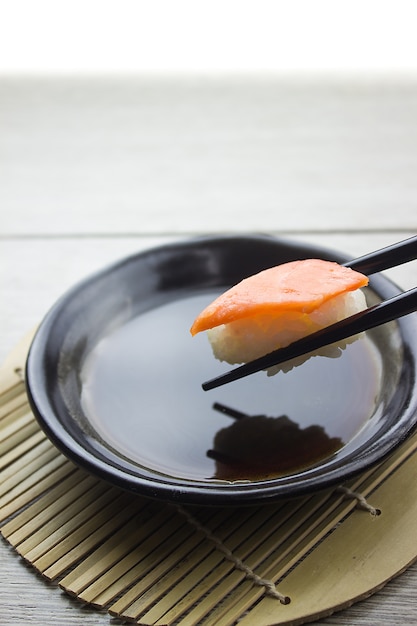 Hand mit Stäbchen pick Sushi