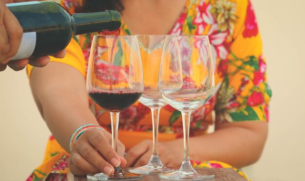 Foto hand poring rotwein zu weingläsern auf dem tisch