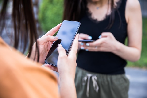 Hand-Smartphone mit zwei Frauen