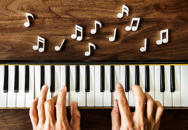 Hand spielt klavier auf holztisch