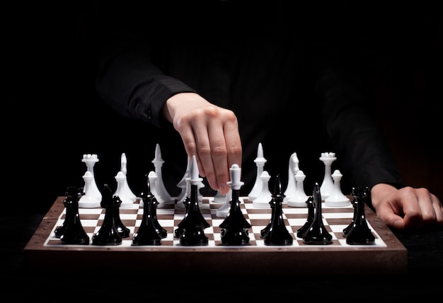 Hand spielt Schach in der Dunkelheit