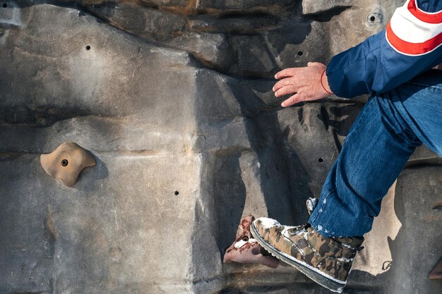 Hand und Bein des männlichen Bergsteigertrainings an der Kletterwand