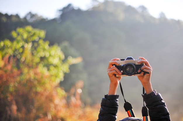 Hand und Kamera des Fotografen im Wald. Seine Liebe zur Fotografie und seiner Kamera.