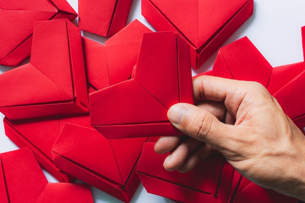 Hand und rotes Papierherz, rotes Herz in der Frauenhand lokalisiert auf Weiß. Valentinstag