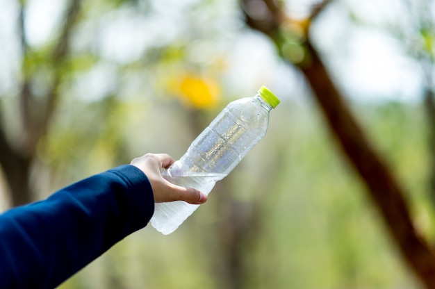 Hand- und Wasserflasche Kreatives Konzept des Trinkwassers mit Kopienraum