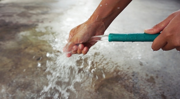 Hand vom Schlauch im Freien waschen