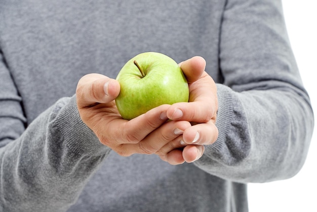 Hand-Wellness und Mann in einem Studio mit einem Apfel für die Ernährung und einem gesunden Snack mit Vitaminen Gesundheit natürlicher und gesunder Mann oder Person mit frischen organischen und rohen grünen Früchten für ein Verlangen