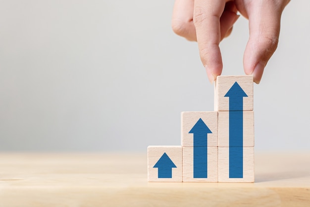Handanordnung Holzblockstapelung als Stufentreppe mit Pfeil nach oben