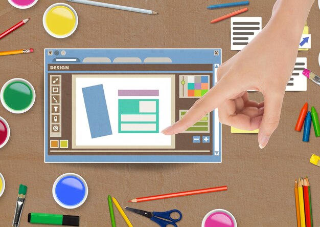 Handberührendes Design-Editor-Fenster und kreative Kunstobjekte auf Papier ausgeschnittenem Desktop